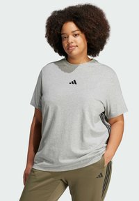 Gray cotton t-shirt with short sleeves, round neckline, and black Adidas logo. Paired with olive green pants featuring black side stripes.