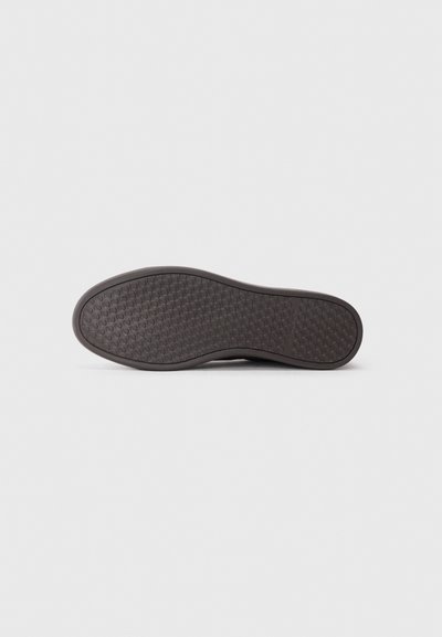 Talpa de pantof în cauciuc de culoare maro închis, cu un grip texturat și patternat. Vârf ușor rotunjit și margini netede. Design curat, minimalist.