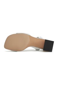 Sandal con tacco bianco dal finish opaco, con una suola beige liscia e un tacco nero testurizzato, adatta per occasioni formali.