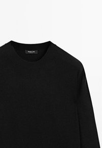 Czarny wełniany sweter z okrągłym dekoltem, o gładkiej fakturze i minimalistycznym designie; etykieta "Massimo Dutti" widoczna przy kołnierzu.