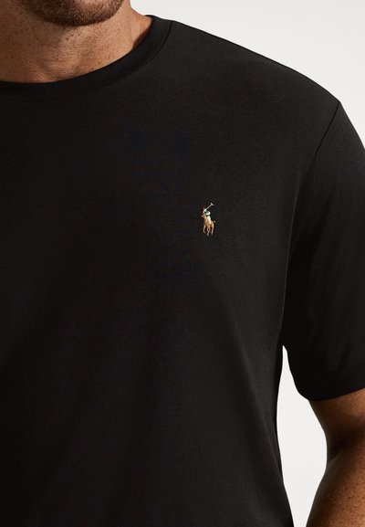 Svart t-shirt med korta ärmar i mjuk bomull, med en liten broderad polo-spelare-logga i färg på vänstra bröstet.