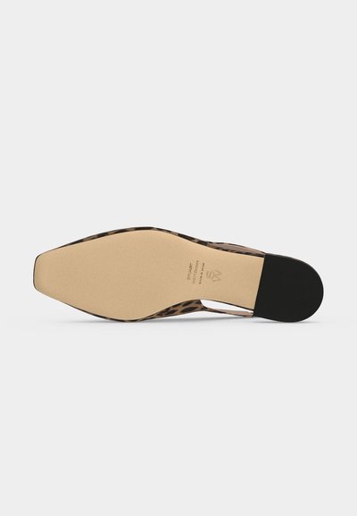 Flat såle på sko med leopardmønster øverst synlig rundt kantene, beige base og liten svart hæl. Teksten lyder "Stuart Weitzman."
