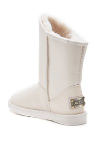 Stivale bianco a metà polpaccio realizzato in morbida pelle con rivestimento in pelliccia. Presenta una suola piatta e un accento metallico brandizzato sul retro.