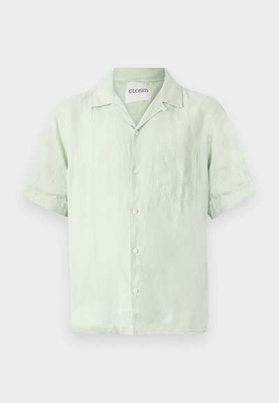 Πουκάμισο με κοντά μανίκια, σε ανοιχτό πράσινο χρώμα από λινό, με κουμπιά στην μπροστινή πλευρά, γιακά και μία τσέπη στο στήθος. Ήπια υφή και άνετη γραμμή.