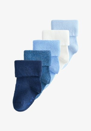 Öt pár összehajtott baba zokni, sötét tengerészkéktől a fehérig terjedő színátmenetben, egymáson átfedve elrendezve egy fehér háttéren.