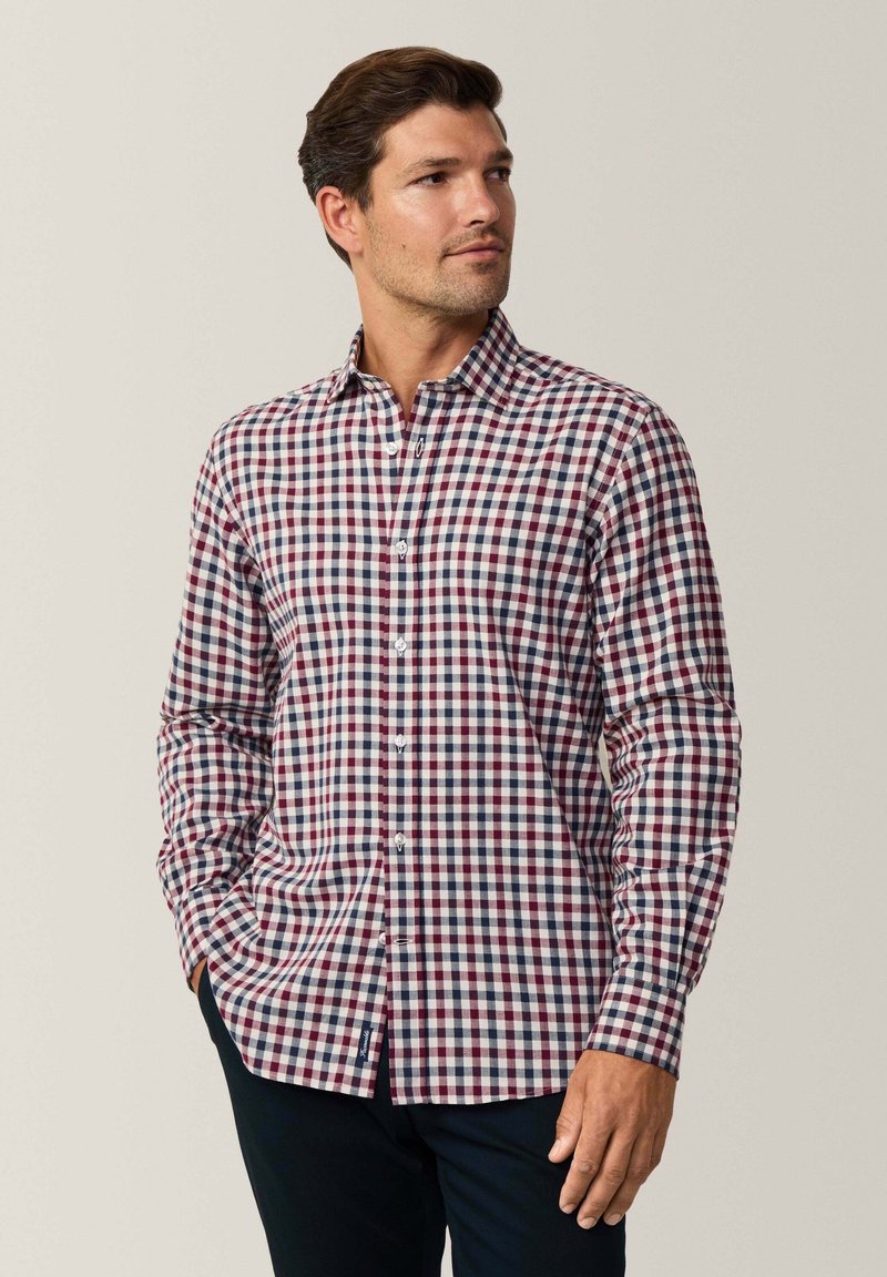 Camicia a maniche lunghe con bottoni in un motivo a quadri rosso, blu navy e bianco. Caratterizzata da un colletto classico e un design aderente. Tessuto in cotone.