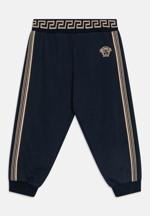 Marineblå joggingbukser med beige sidelister, ribstrikkede manchetter og linning med et græsk nøglemønster samt et lille Medusa-hovedlogo.