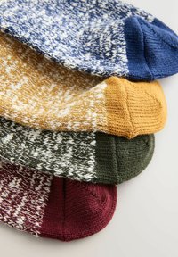 Gestrickte Socken in Blau, Senf, Grün und Burgunderrot. Jede Socke hat ein gesprenkeltes Design mit kontrastierenden einfarbigen Bündchen und Zehen.