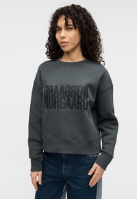 Γκρι φούτερ με ριμπ μάνικες και τελείωμα, με μεγάλο μαύρο τυπωμένο κείμενο. Ομαλή υφή, άνετη εφαρμογή και σχέδιο με στρογγυλή λαιμόκοψη.