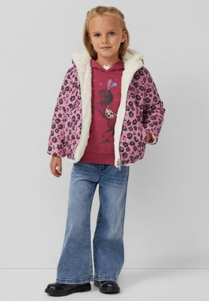 Rosa Leopardenmuster-Mantel mit einer weißen, pelzgefütterten Kapuze, kombiniert mit einem kastanienbraunen Hoodie mit einem Pferdemotiv und blauen Schlagjeans.