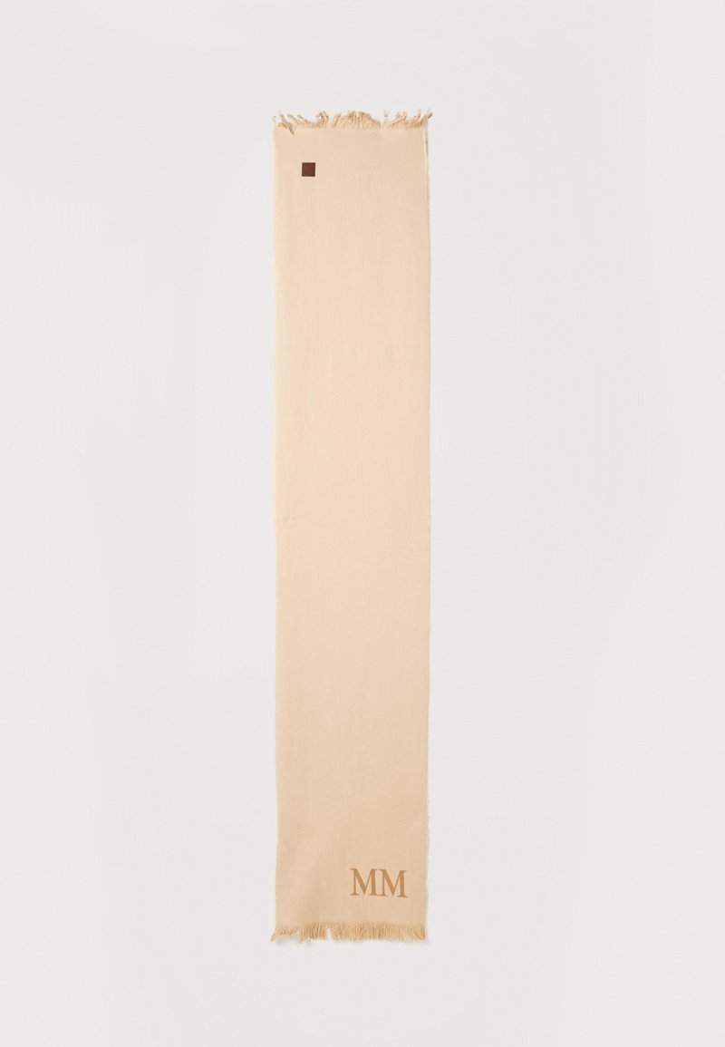 Μακρύ μπεζ κασκόλ με φουντάκια στις άκρες και μικρά καφέ γράμματα "MM" κοντά σε ένα από τα φουντάκια, απλωμένο επίπεδα σε λευκό φόντο.