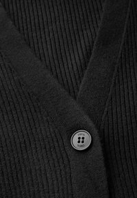 Schwarze gerippte Strickjacke mit V-Ausschnitt, aus strukturiertem Stoff und mit einem runden Kunststoffknopf, der die Marke "Cecil" kennzeichnet.