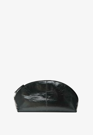 Sort kosmetiktaske i læder med rund form, lynlåslukning og glat tekstur. Har en flad bund for stabilitet.