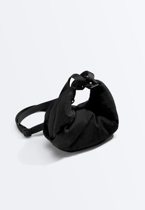 Geantă de talie neagră căptușită, cu curea reglabilă din material împletit și închidere cu cataramă, pe fundal alb.