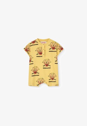 Jumpsuit amarillo de manga corta hecho de algodón, con un diseño gráfico de perro repetido y texto, con escote tipo henley y cierre a presión.