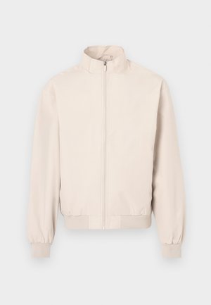 Helebeež, pikkade varrukatega kerge jakk, kõrge kraega, täispikk ees lukuga, elastsete mansettide ja vöökohaga.