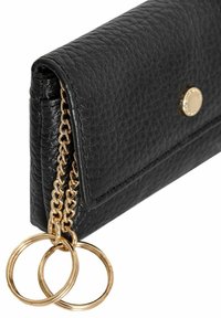 Czarny skórzany portfel o fakturowanym wykończeniu, z złotym zapięciem na nap oraz łańcuszkiem z dwoma złotymi pierścieniami.
