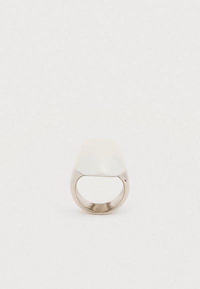 Λευκό ημικυκλικό δαχτυλίδι με λεία γυαλιστερή επιφάνεια· μεταλλική μπάντα σε ασημί απόχρωση. Απλός σχεδιασμός, μοντέρνα μορφή και αρμονικό φινίρισμα.