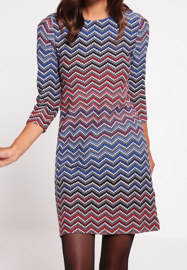Šaty ke kolenům s barevným zigzagovým vzorem v červené, modré a černé barvě. Vyrobeno z texturového materiálu, s třičtvrtinovými rukávy.