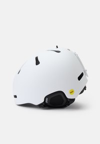 Weißer Skihelm mit Belüftungsöffnungen, schwarzen Akzenten und gelbem MIPS-Label. Abgerundete Form, gepolsterter Innenraum und verstellbare Riemen.