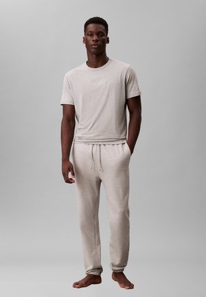 Hellgraues Baumwoll-T-Shirt mit Rundhalsausschnitt und kleinem Logo; passende hellgraue Jogginghosen mit elastischem Bund und Bündchen.