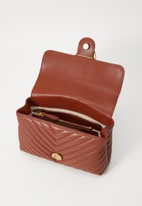 Brun lærveske med kviltet chevron-mønster, gullhardware og et romslig interiør med en glidelåslomme.