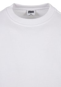 Vit sweatshirt med en ribbad rund halsringning, tillverkad av bomullsmaterial, med en etikett som läser "URBAN CLASSICS" och storlek "M."