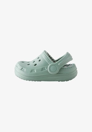 Sabot vert clair à enfiler avec des trous de ventilation, une bride de talon réglable et une semelle matelassée avec une doublure intérieure à carreaux.