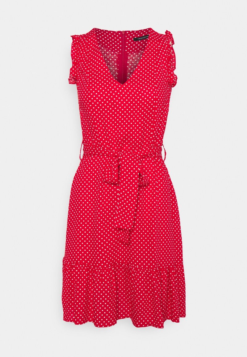 Robe rouge sans manches à pois blancs, col en V, manches à volants, ceinture taille et ourlet à volants, longueur genou.