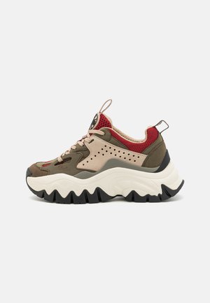 Zapatillas chunky que presentan una mezcla de materiales de malla y ante en verde oliva, beige y rojo. Suela intermedia blanca gruesa con una suela exterior negra estriada.