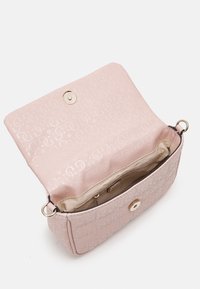 Różowa torebka wykonana z teksturowanego materiału, z wzorem logo, zamknięciem na magnetyczny zatrzask oraz wewnętrzną przegrodą z jasną podszewką.
