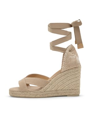 Sandalo con zeppa in corda beige con plateau in juta intrecciata, cinturini frontali incrociati, tacco intrecciato e laccio lungo da avvolgere alla caviglia.