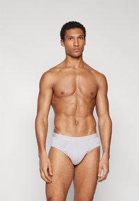 Graue Baumwollunterhosen mit glatter Textur und einem weichen elastischen Bund. Sie verfügen über ein minimalistisches Design mit einem leichten Glanz.