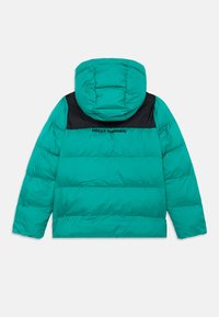 Tyrkysová páperová bunda s čiernym prešívaním a kapucňou, s vyšitým logom "Helly Hansen" na hornej časti chrbtovej strany.
