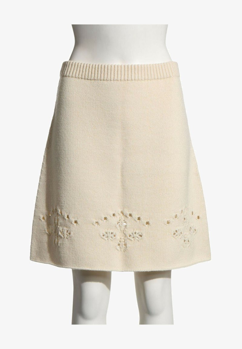 Jupe tricotée crème longueur genou avec taille côtelée et motif floral délicat découpé près de l'ourlet.