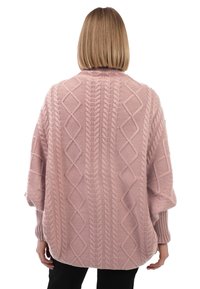 Cárdigan de punto oversized en rosa claro con diseño de trenzas, que presenta patrones de diamante y puños acanalados. Tejido texturizado y ajuste holgado.