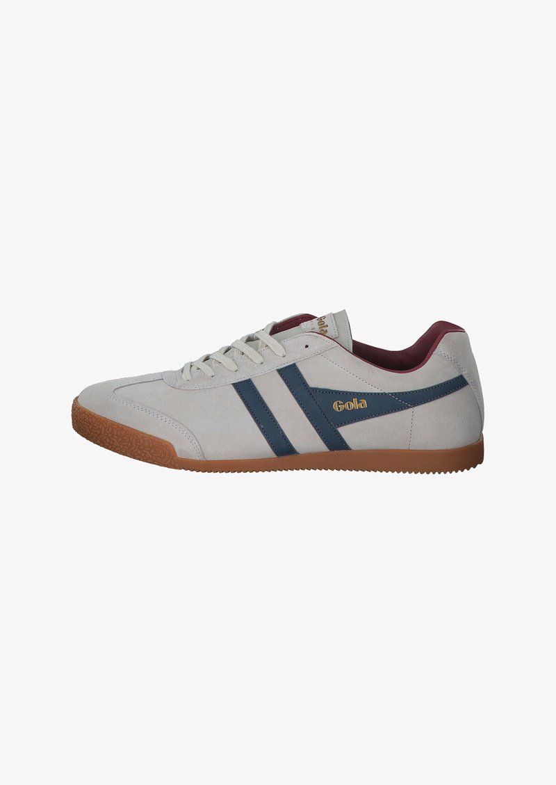 Grijze suède lage sneakers met marineblauwe strepen, voorzien van een gumrubberen zool en een bordeauxrood interieur. Gouden logo aan de zijkant.