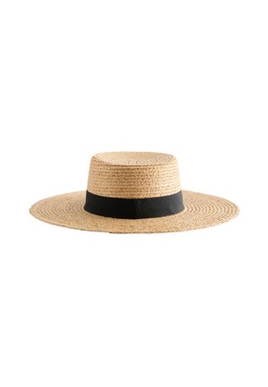 Chapeau de paille tissé à large bord avec une calotte plate et un ruban de tissu noir autour de la base de la calotte.