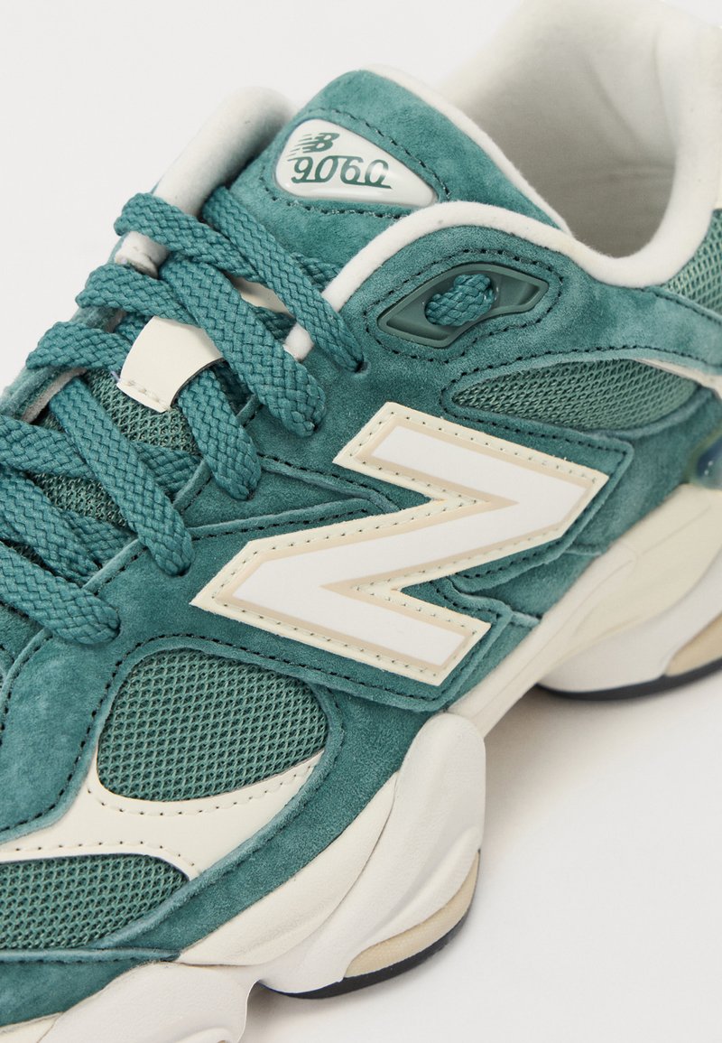 Türkise Wildledersneaker mit Mesh-Akzenten, strukturierten Schnürsenkeln, weißen Logodetails und einer gepolsterten Sohle. Verfügt über ein Logo an der Zunge und einen gepolsterten Kragen.