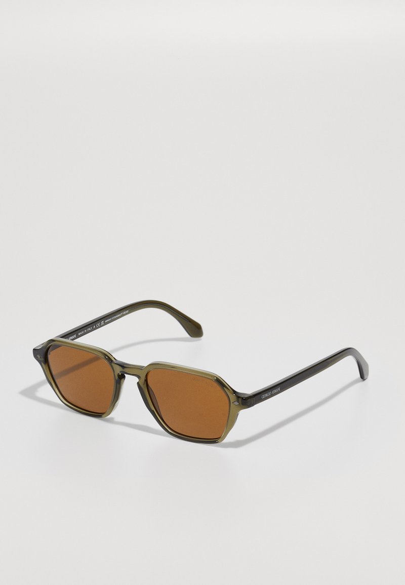 Green-tinted sunglasses with rectangular brown lenses, featuring a bold, chunky frame design and dark arms with engraved logo detail.