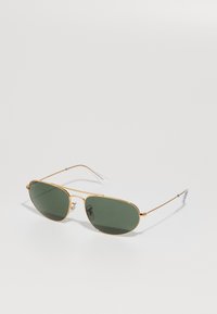 Occhiali da sole in metallo dorato con lenti verde scuro, forma ovale, montatura in filo sottile, cuscinetti nasali in acetato e punte delle tempie in gomma trasparente.