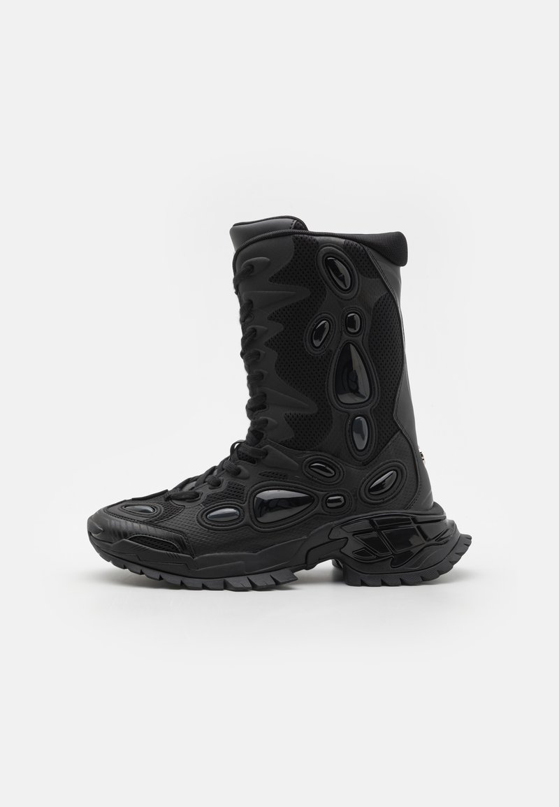 Bottes noires mi-mollet avec une tige en mesh texturé, des accents en caoutchouc moulé et une semelle épaisse avec des crampons prononcés.