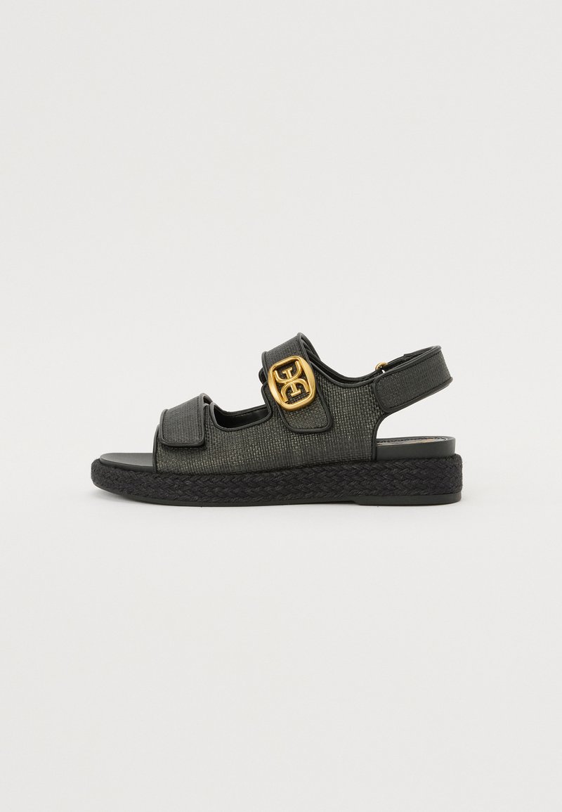 Mustal espadrille sandaalid tekstuuriga pealsega, reguleeritavad rihmad ja kuldse logoga aktsent. Lame tald kootud detailiga. Reguleeritav kandstrap.