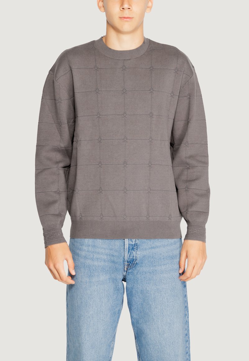 Maglione grigio in maglia con un motivo a griglia testurizzato, polsini e scollatura a coste, abbinato a jeans azzurri chiari.