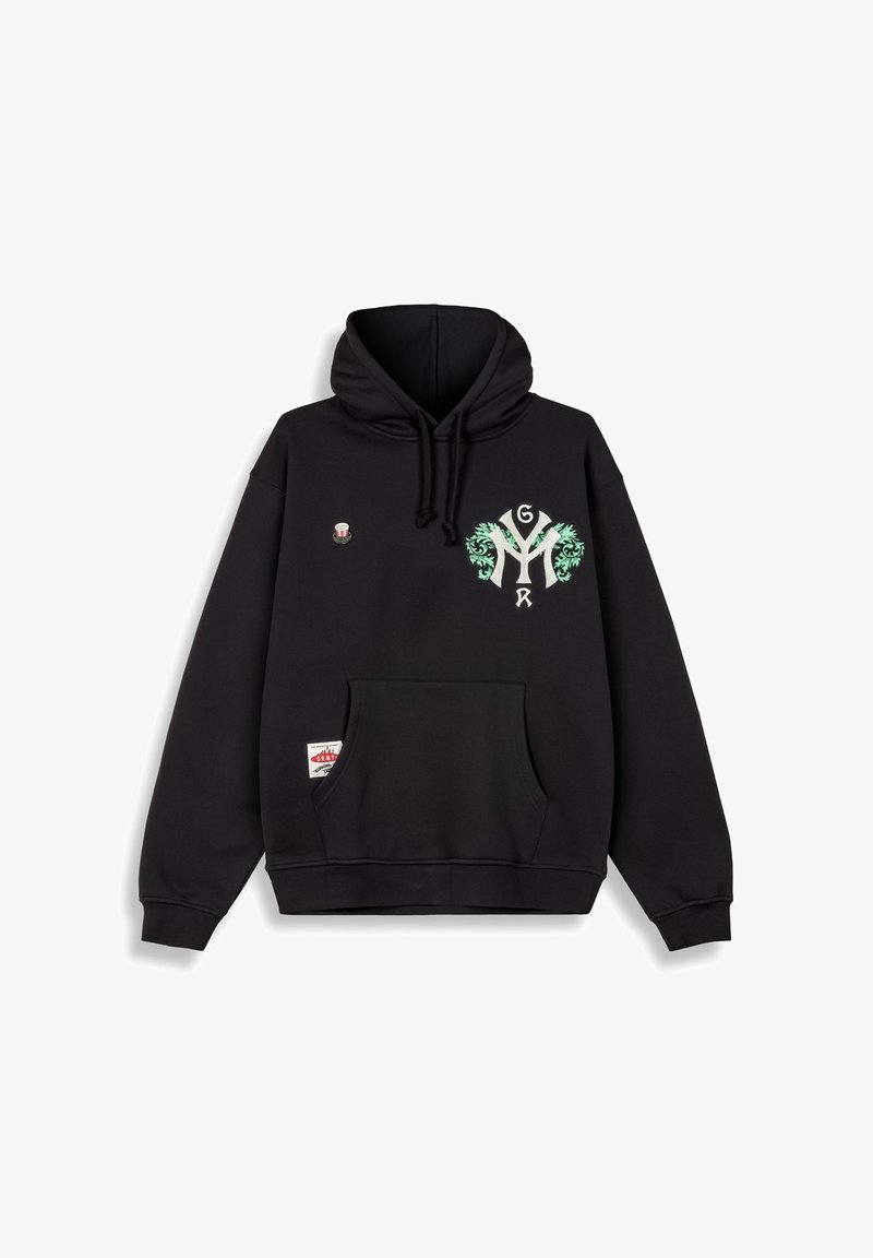 Sudadera negra con un gran motivo blanco de "Y" con acentos florales verdes, un pequeño pin en el pecho y un bolsillo canguro en la parte frontal.