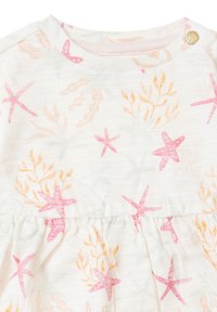 Witte stoffen jurk met roze en oranje sterfishes en loofpatronen. Beschikt over een geplooide taille en een drukknoopsluiting op de schouder.