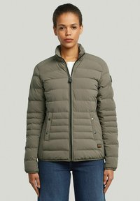 Gewatteerde jas in olijfgroen met verticale stiksels, een staande kraag, voorrits en drukknopzakken. Gelaagde oppervlakte en casual ontwerp.
