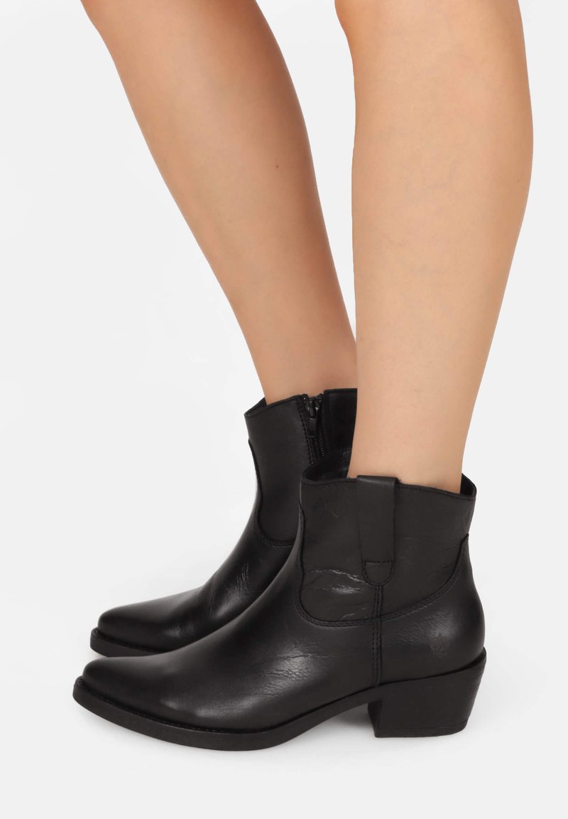 Zwarte lederen enkellaarsjes met een ronde neus, lage blokhak en zijritssluiting. Ze hebben een gladde textuur en minimalistische accenten.