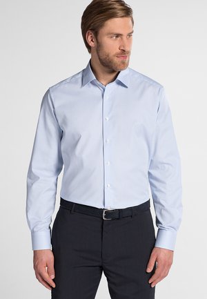 Hellblau gestreiftes Hemd mit langen Ärmeln, spitzen Kragen, Knopfverschluss und glatter Stofftextur, getragen mit dunkler Hose und Gürtel.