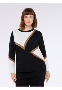 Maglione bianco e nero con accenti marroni. Presenta un design geometrico, maniche lunghe e colletto a giro. Tessuto a maglia morbido con motivi a contrasto.